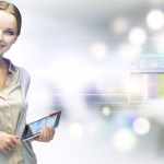 **Textvorschlag:** Eine freundliche, professionelle junge Frau präsentiert ein Tablet, das sie in den Händen hält und bedient. Ihr Lächeln und die offene Haltung vermitteln Kompetenz und Zugänglichkeit. Der Hintergrund ist eine modern anmutende, helle Büroumgebung, durch die digitale Overlays in Form von Datentabellen und Icons schweben. Dies symbolisiert die nahtlose Integration von Technologie und Datenmanagement in den heutigen Geschäftsalltag und veranschaulicht die Effizienz digitaler Lösungen. **Alternativtext:** Lächelnde Geschäftsfrau hält ein Tablet vor einem unscharfen Bürohintergrund mit digitaler Datenanzeige.