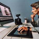 Ein Mann konzentriert sich auf die Bildbearbeitung einer Armbanduhr auf einem Computermonitor und nutzt dabei ein Grafiktablett.