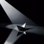 Ein schlichtes Papierboot in einem intensiven Lichtkegel auf dunklem, spiegelndem Grund.