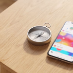 Ein Kompass neben einem Smartphone mit einem Social-Media-Feed auf einem Holztisch, das die Navigation in der digitalen Welt symbolisiert.