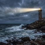Ein Leuchtturm strahlt sein Licht über eine stürmische See mit aufprallenden Wellen und dunklen Wolken, von einer felsigen Küste aus.